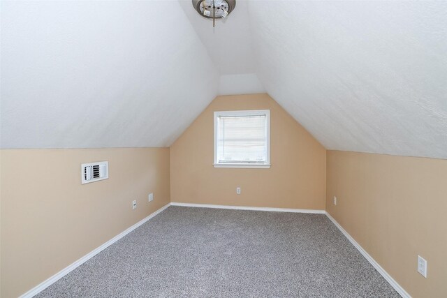 bonus room featuring vaulted ceiling, carpet floors, and a textured ceiling