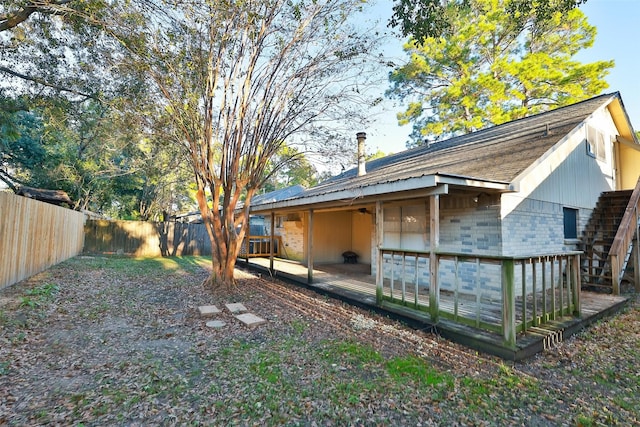 9130 Kirkleigh St, Spring, TX 77379 - rear view of house featuring a fenced backyard, a wooden deck, brick siding, and a shingled roof