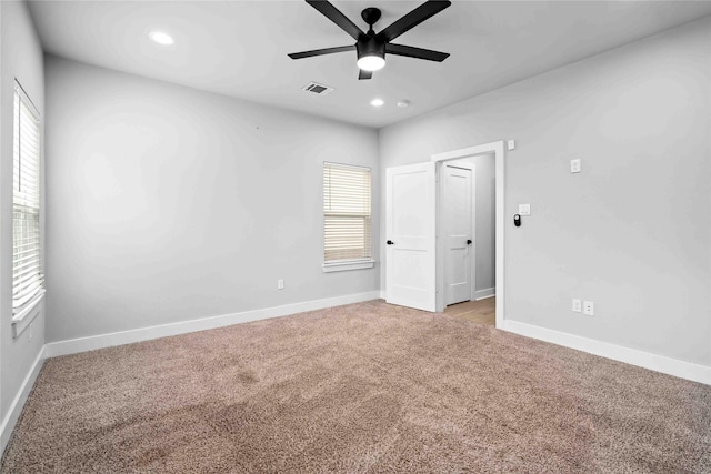 spare room with light colored carpet and ceiling fan