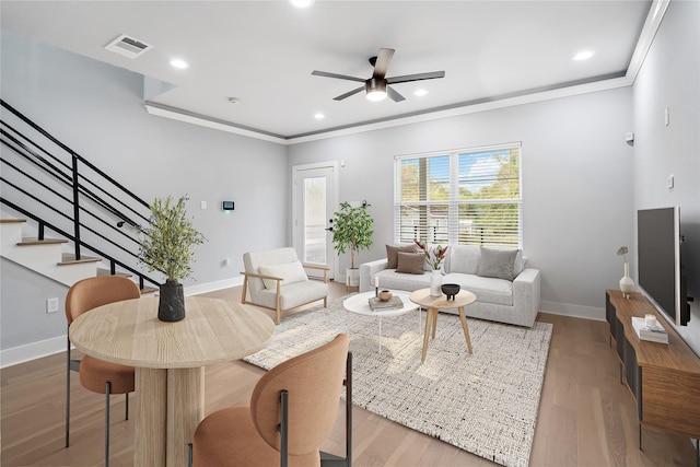 living room with crown molding, ceiling fan, and hardwood / wood-style flooring