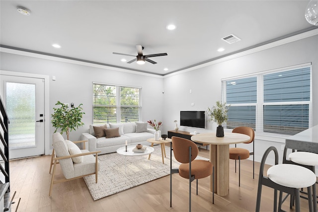 living room with ceiling fan, light hardwood / wood-style floors, and crown molding