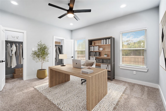 carpeted home office featuring ceiling fan