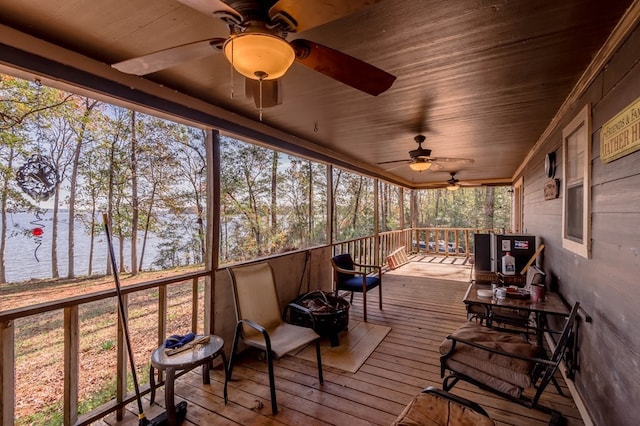 sunroom featuring a water view