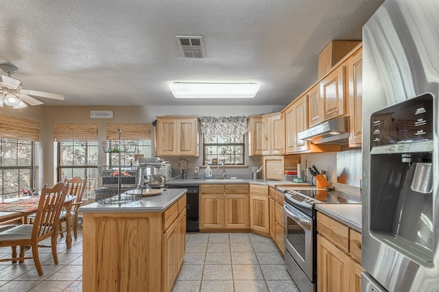 kitchen with a center island, light brown cabinets, sink, light tile patterned flooring, and stainless steel appliances