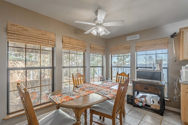 dining space featuring ceiling fan, light tile patterned floors, and a textured ceiling