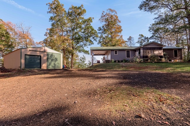 exterior space with a sunroom, an outbuilding, and a garage