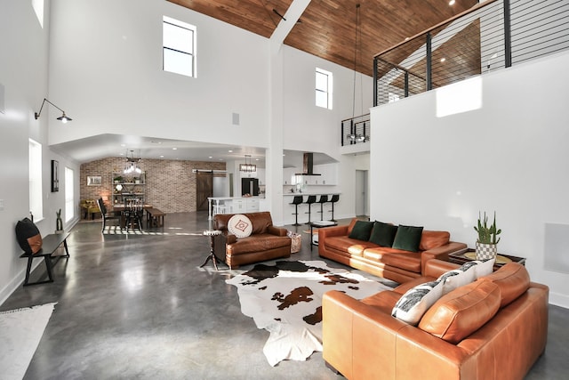 living room featuring brick wall, a towering ceiling, a notable chandelier, and wood ceiling