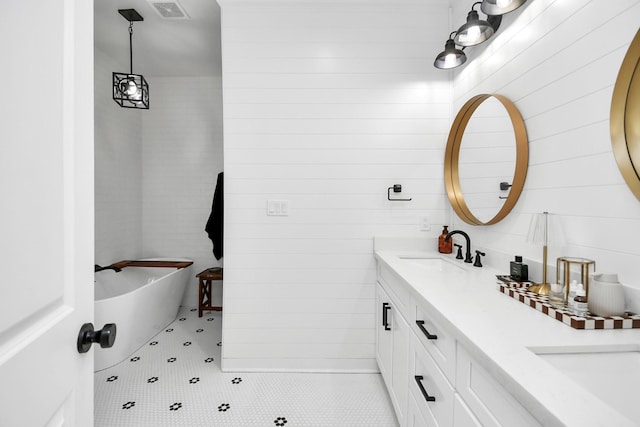 bathroom featuring vanity, tile patterned floors, and a bathing tub