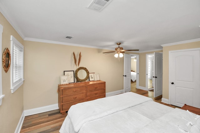 bedroom featuring ceiling fan, hardwood / wood-style floors, and crown molding