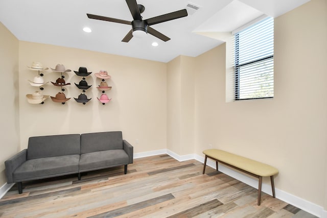 living area with light hardwood / wood-style floors and ceiling fan