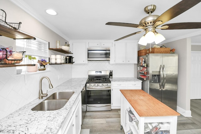 kitchen with wooden counters, appliances with stainless steel finishes, sink, white cabinets, and dark hardwood / wood-style floors