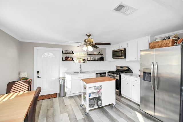 kitchen featuring white cabinets, light hardwood / wood-style floors, sink, and appliances with stainless steel finishes