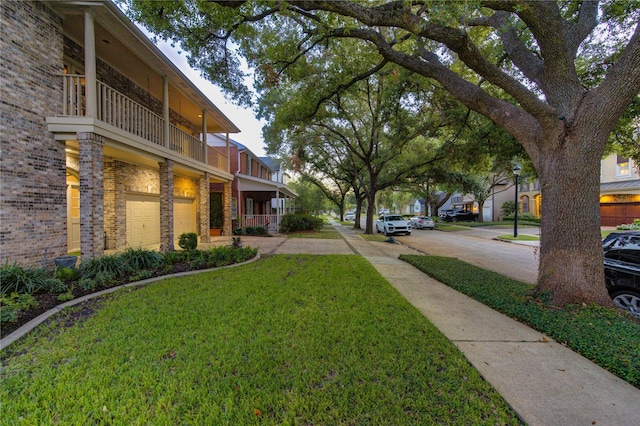 view of yard with a balcony and a garage