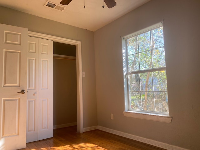 unfurnished bedroom featuring a closet, light hardwood / wood-style flooring, and ceiling fan