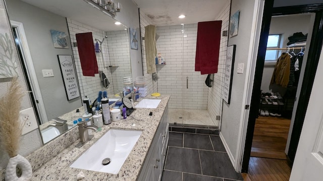 bathroom featuring hardwood / wood-style flooring, vanity, and walk in shower