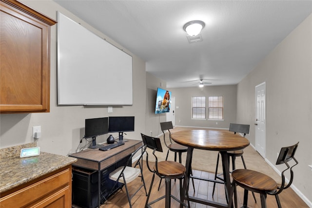 dining area with light hardwood / wood-style floors and ceiling fan