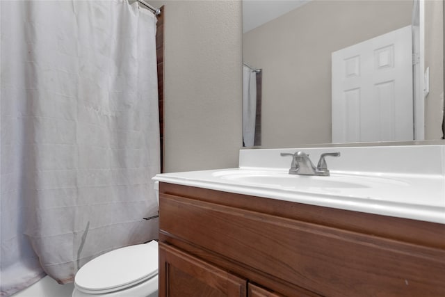 bathroom with vanity, curtained shower, and toilet