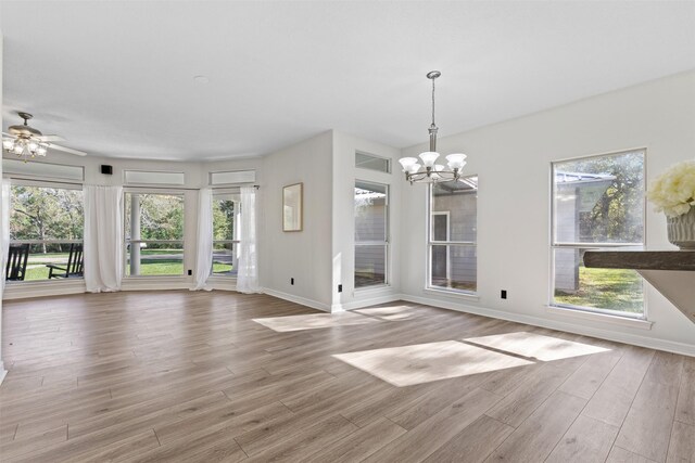 interior space with light hardwood / wood-style floors and ceiling fan with notable chandelier