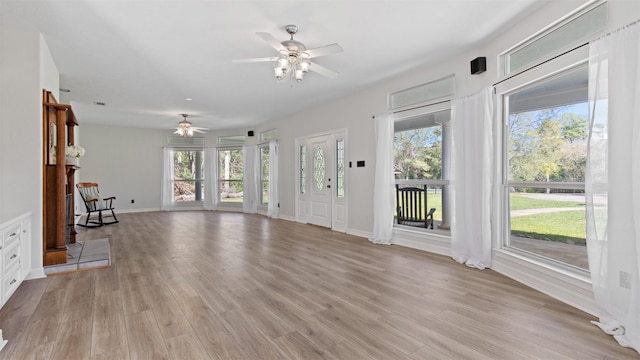 unfurnished living room with ceiling fan and light wood-type flooring