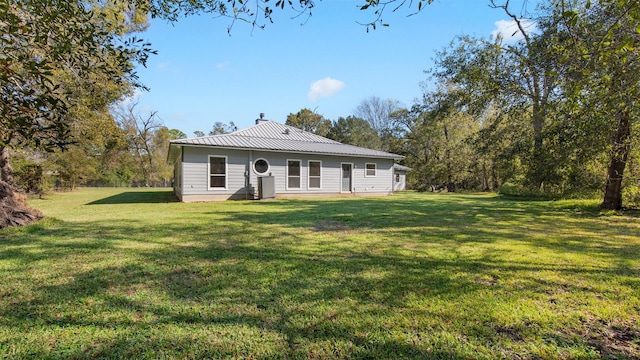 rear view of property with a yard