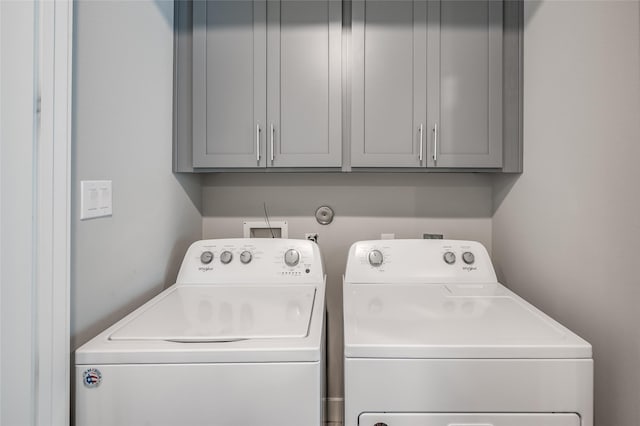 laundry room featuring cabinets and washing machine and dryer