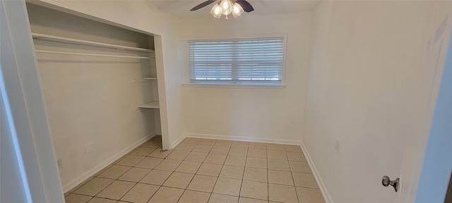 unfurnished bedroom featuring ceiling fan, light tile patterned flooring, and a closet