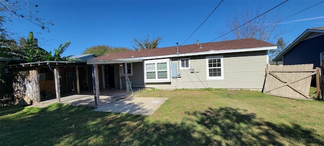 rear view of house with a lawn and a patio