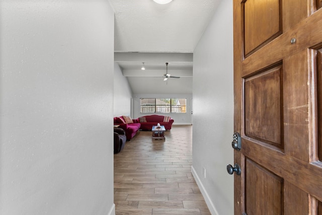 foyer with ceiling fan, lofted ceiling, and light wood-type flooring