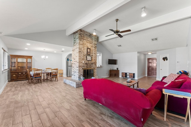 living room with ceiling fan, lofted ceiling with beams, and a fireplace