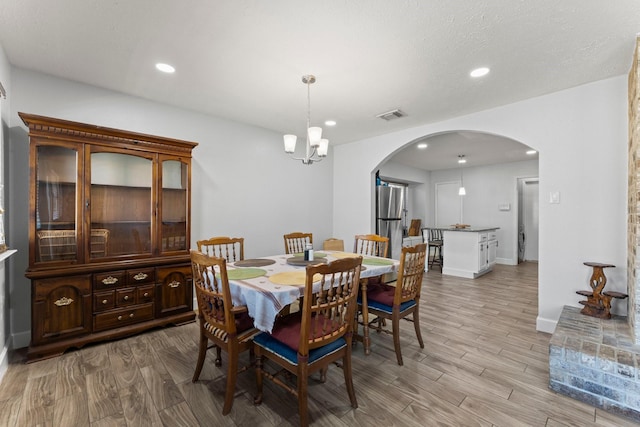 dining area featuring light wood-type flooring and a chandelier