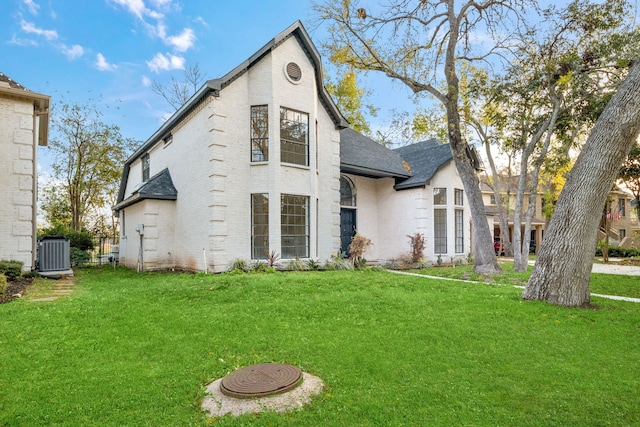 view of front facade featuring central AC unit and a front lawn