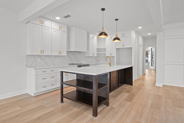 kitchen with backsplash, white cabinetry, and light hardwood / wood-style floors