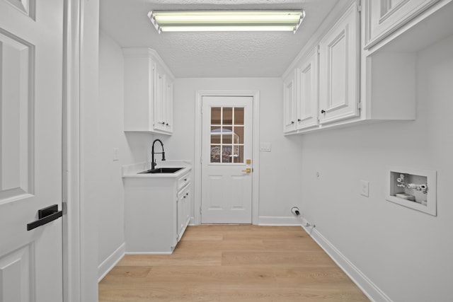 laundry room with sink, cabinets, washer hookup, gas dryer hookup, and light wood-type flooring