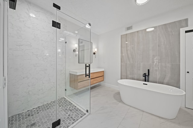 bathroom featuring a textured ceiling, vanity, independent shower and bath, and tile walls