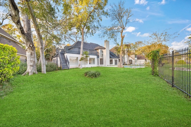 view of yard featuring a balcony and a fenced in pool