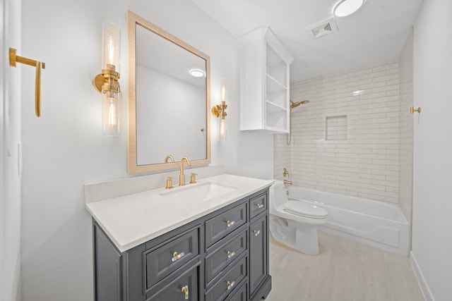 full bathroom with toilet, vanity, and tiled shower / bath