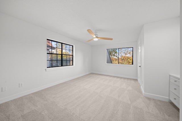 carpeted empty room featuring ceiling fan and a healthy amount of sunlight