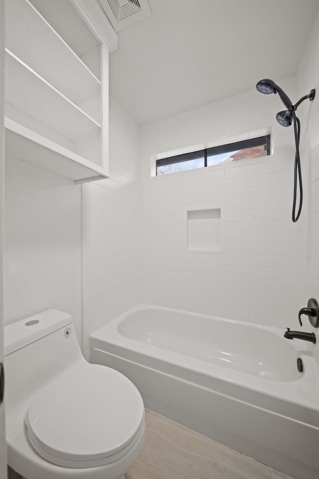 bathroom with tiled shower / bath and toilet