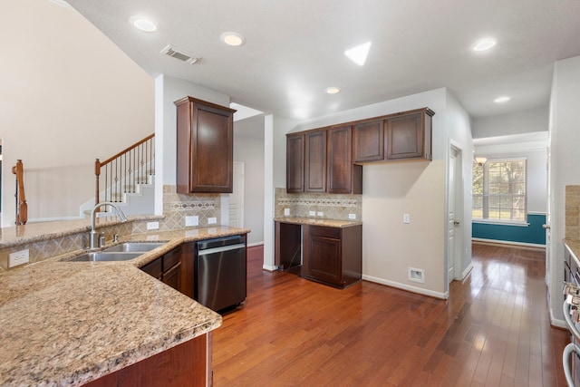 kitchen with kitchen peninsula, dark hardwood / wood-style floors, light stone countertops, stainless steel dishwasher, and sink