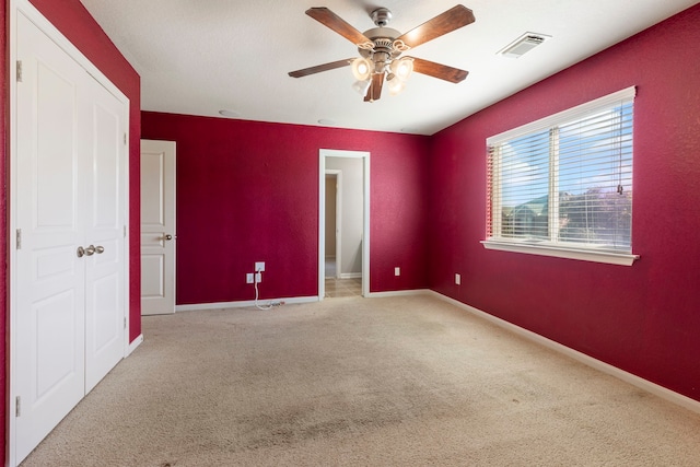 unfurnished room with ceiling fan and light carpet