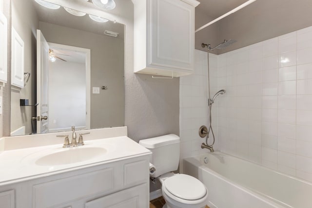 full bathroom featuring toilet, tiled shower / bath, and vanity