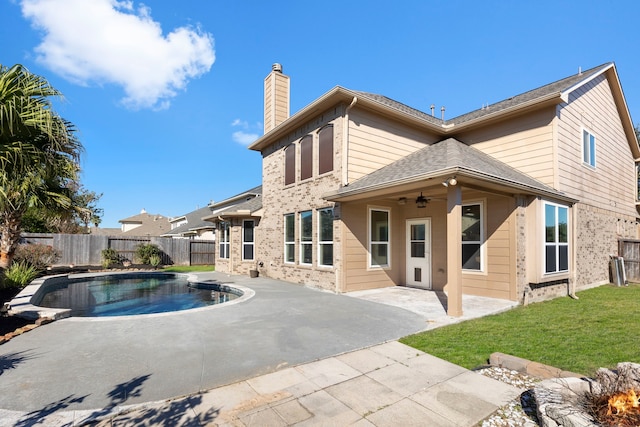 back of house with ceiling fan, a yard, a patio area, and a fenced in pool