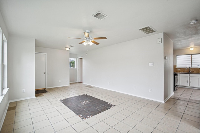 spare room featuring ceiling fan, light tile patterned floors, and sink