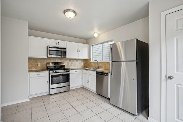 kitchen with backsplash, sink, white cabinets, and appliances with stainless steel finishes