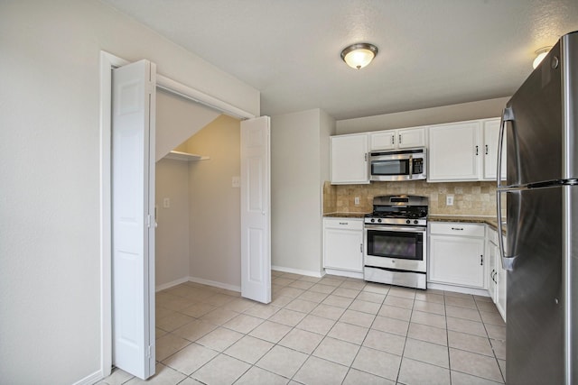 kitchen with decorative backsplash, light tile patterned flooring, white cabinetry, and appliances with stainless steel finishes