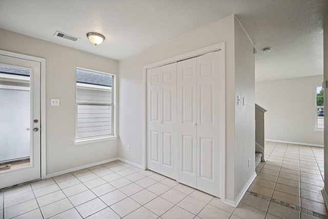 tiled foyer with a textured ceiling