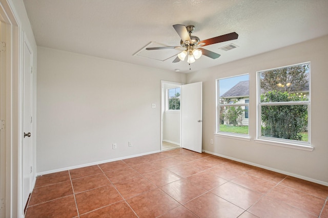 tiled spare room featuring ceiling fan and a textured ceiling