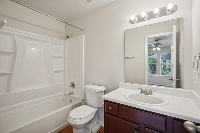 full bathroom with vanity, washtub / shower combination, ceiling fan, toilet, and a textured ceiling