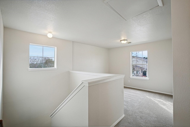 corridor with carpet flooring and a textured ceiling