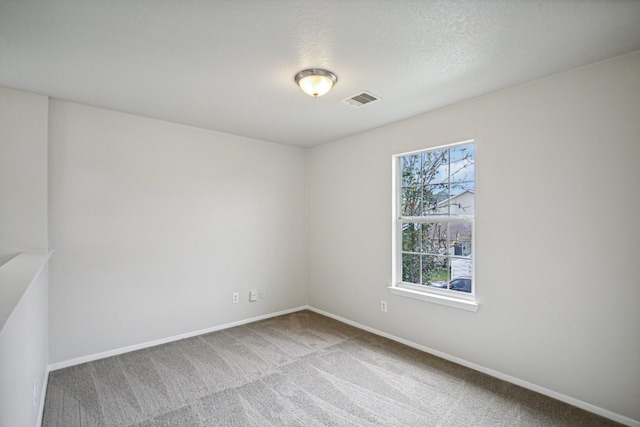 spare room with carpet flooring and a textured ceiling